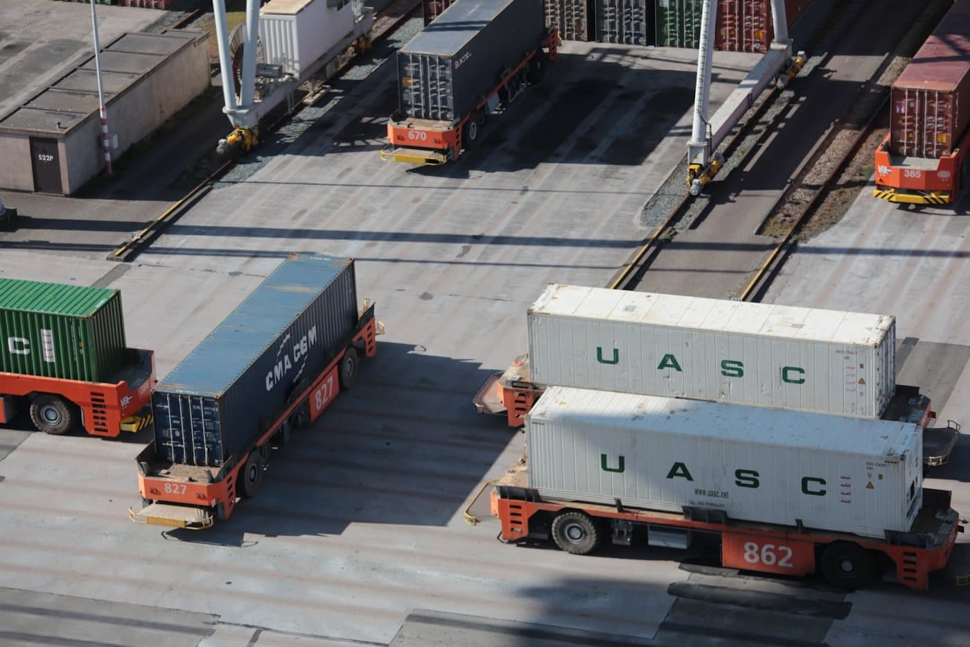 Automated transport vehicles repositioning containers in freight yard