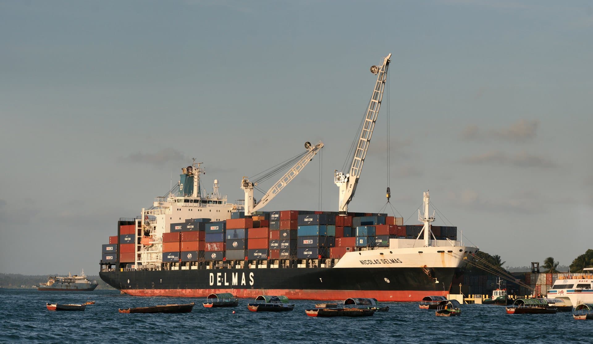 Large commercial container ship loaded with cargo sailing through open waters